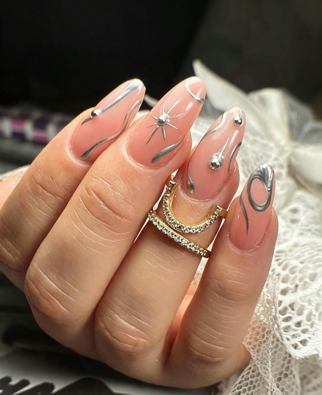 Uñas nude con líneas cromadas y piedras plateadas