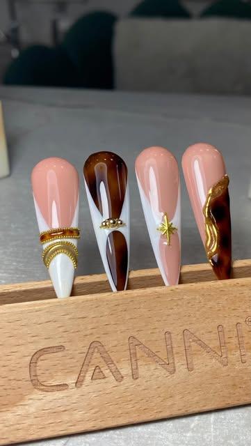 Uñas stiletto nude, blanco y carey sobre un exhibidor de madera
